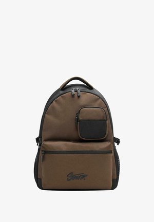 Zaino in tessuto marrone con una tasca nera accentuata, chiusure a zip e logo sul fronte. Parte superiore arrotondata e spallacci regolabili. Design resistente.