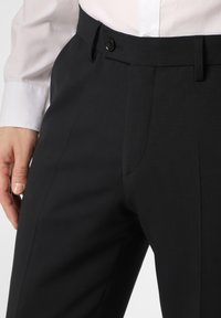 Schwarze formelle Hose aus glattem Stoff, maßgeschneiderte Passform und einknopf Verschluss an der Taille. Verfügt über seitliche Taschen und dezente Nähte.