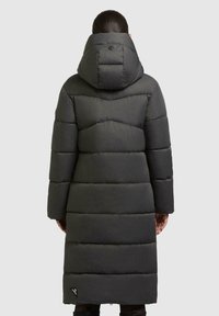 Parka puffer lunga di colore grigio scuro con cappuccio, caratterizzata da sezioni imbottite orizzontali e un piccolo logo vicino all'orlo. Finitura simile alla seta con texture.