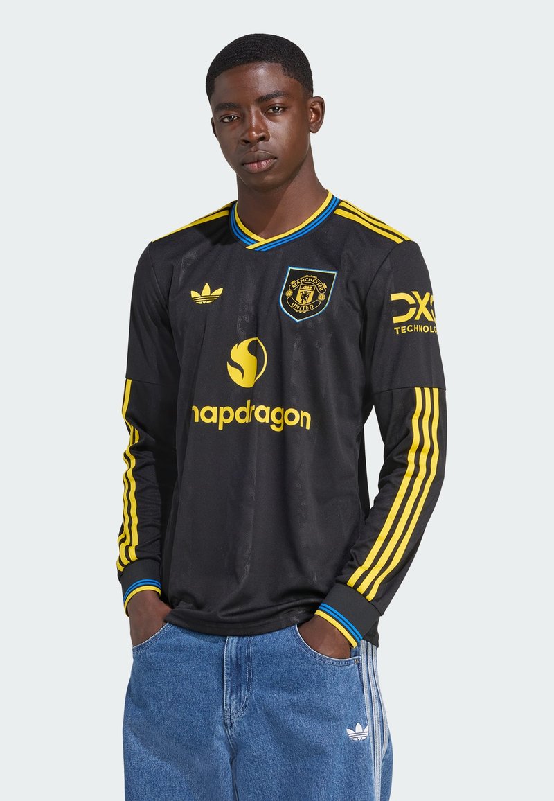 Black long-sleeve soccer jersey with yellow accents, featuring a logo, diagonal stripes on sleeves, and made from a smooth, breathable fabric.