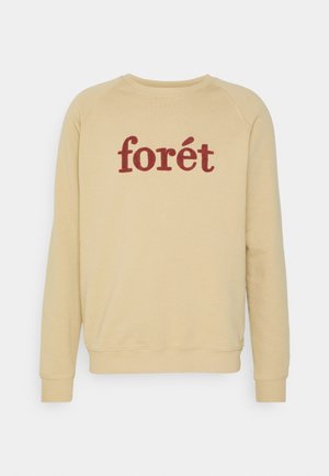 Beige pyöreäkauluksinen collegepaita, jossa pitkät hihat ja punainen "forét"-teksti keskellä edessä.