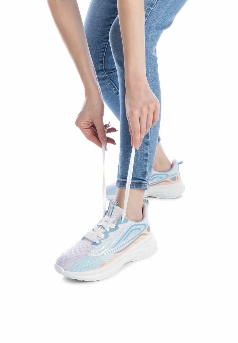 Zapatos atléticos ligeros en blanco con detalles en azul pastel y naranja, que cuentan con una parte superior de malla y una suela gruesa y acolchada.
