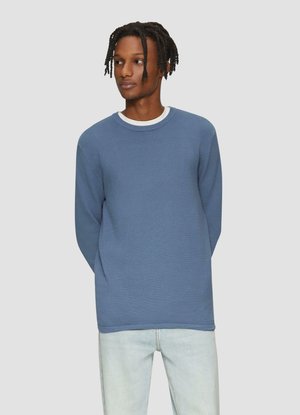 Blauer strukturierter Langarmpullover mit einem gerippten Design und einem weißen Rundhalsausschnitt. Getragen mit hellblauen Jeans.