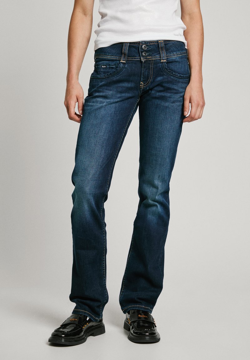 Mørkeblå jeans med rett ben-design, som har subtil falming, kontraststing, to frontlommer og en klassisk knappeåpning.