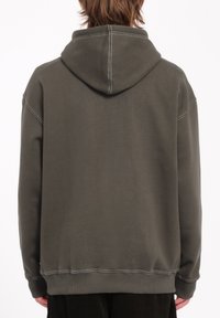 Olijfgroene hoodie met een grote capuchon, geribde manchetten en zoom, en contrasterende witte stiksels. Zacht materiaal met een Relaxed fit, achteraanzicht.
