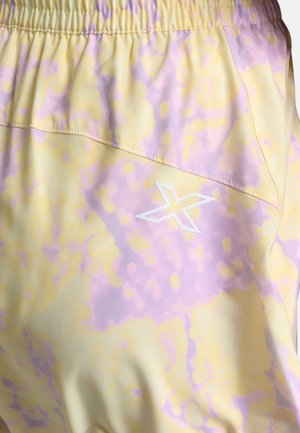 Pantaloni leggeri in un tessuto giallo pastello con motivo a macchie viola. Presentano una vita elastica e un dettaglio del logo bianco.