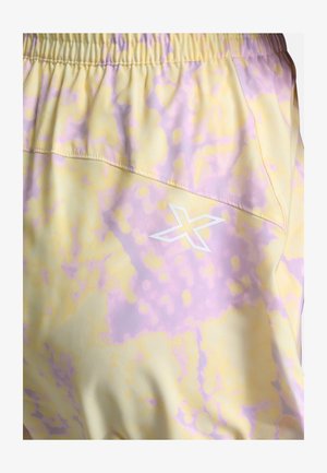 Lekkie szorty w pastelowożółtej tkaninie z fioletowym wzorem w plamy. Posiadają elastyczny pas i biały detal z logo.