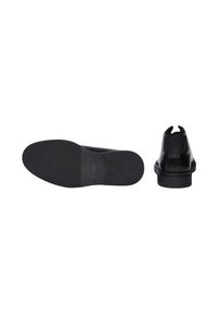 Scarpa in pelle nera con una finitura liscia, dotata di suola in gomma piatta e punta arrotondata. Nessun motivo o dettaglio visibile.