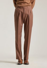 Pantalones plisados marrones con un corte a medida, hechos de una tela texturizada. Presentan un cierre de botón único y un diseño de pierna recta.