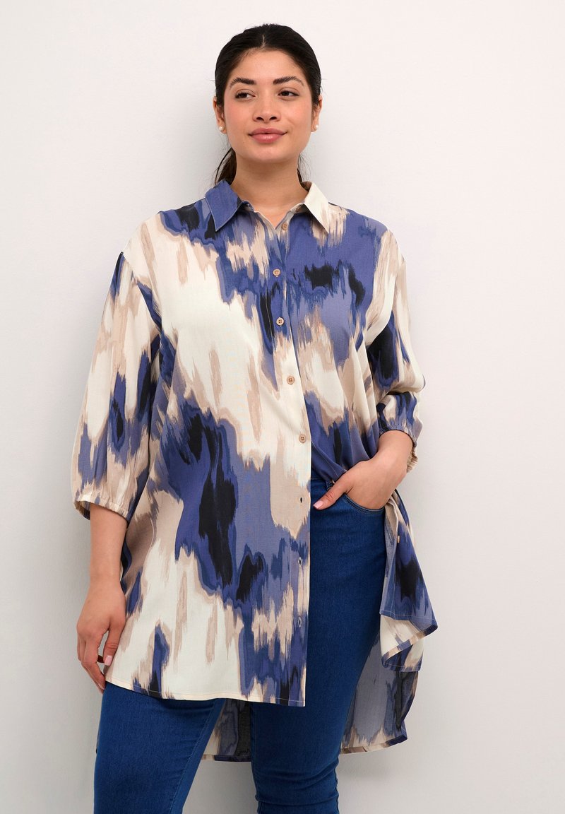 Button-up shirt in light fabric with a blue and beige abstract pattern, featuring a pointed collar and three-quarter sleeves.