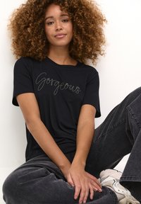 Sort bomuld t-shirt med korte ærmer, der har skrå sølvbroderi med teksten "Gorgeous" tværs over brystet; afslappet pasform og blød tekstur.