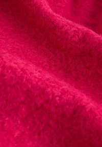 Material roz pufos cu suprafață texturată, afișând o culoare bogată și vibrantă și o calitate tactilă moale. Ideal pentru îmbrăcăminte sau accesorii călduroase.