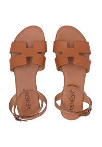 Tan leren sandalen met een ontwerp van brede banden, uitsnijdingen en een dunne enkelband met een gesp. Platte zolen voor comfort.