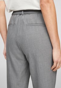 Grijze op maat gemaakte broeken van een gestructureerde stof, met een achterpand en twee achterzakken, met een aansluitende tailleband en riemlussen.