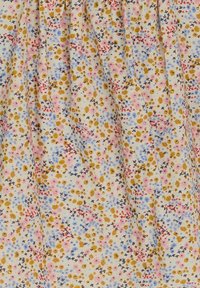 Tissu floral présentant de petites fleurs jaunes, roses, bleues et rouges sur un fond crème. La texture semble douce avec des détails de design froncés.