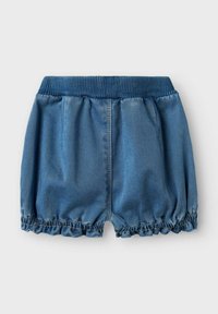 Pantalones cortos de mezclilla con un dobladillo fruncido y con volantes, cintura elástica y textura suave en un color azul medio. Diseño casual, tejido ligero.