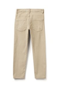 Béžové kalhoty z jemné bavlny s úzkým střihem, které mají dvě zadní kapsy, vyšívané logo a hladkou texturu.