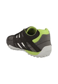 Sneaker con una toma superiore in suede grigio scuro, strisce bianche e accenti verde brillante. Presenta una suola testurizzata per trazione e un interno ammortizzato.