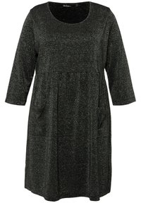 Robe noire en tissu texturé avec des fils brillants. Elle possède un décolleté rond, des manches trois-quarts et deux poches latérales.