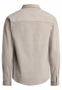 Jasnobeżowa koszula z długim rękawem i kołnierzykiem, wykonana z teksturowanej tkaniny, z zaokrąglonym dołem i zapinanymi mankietami. Widok od tyłu ukazuje prosty design bez zdobień.