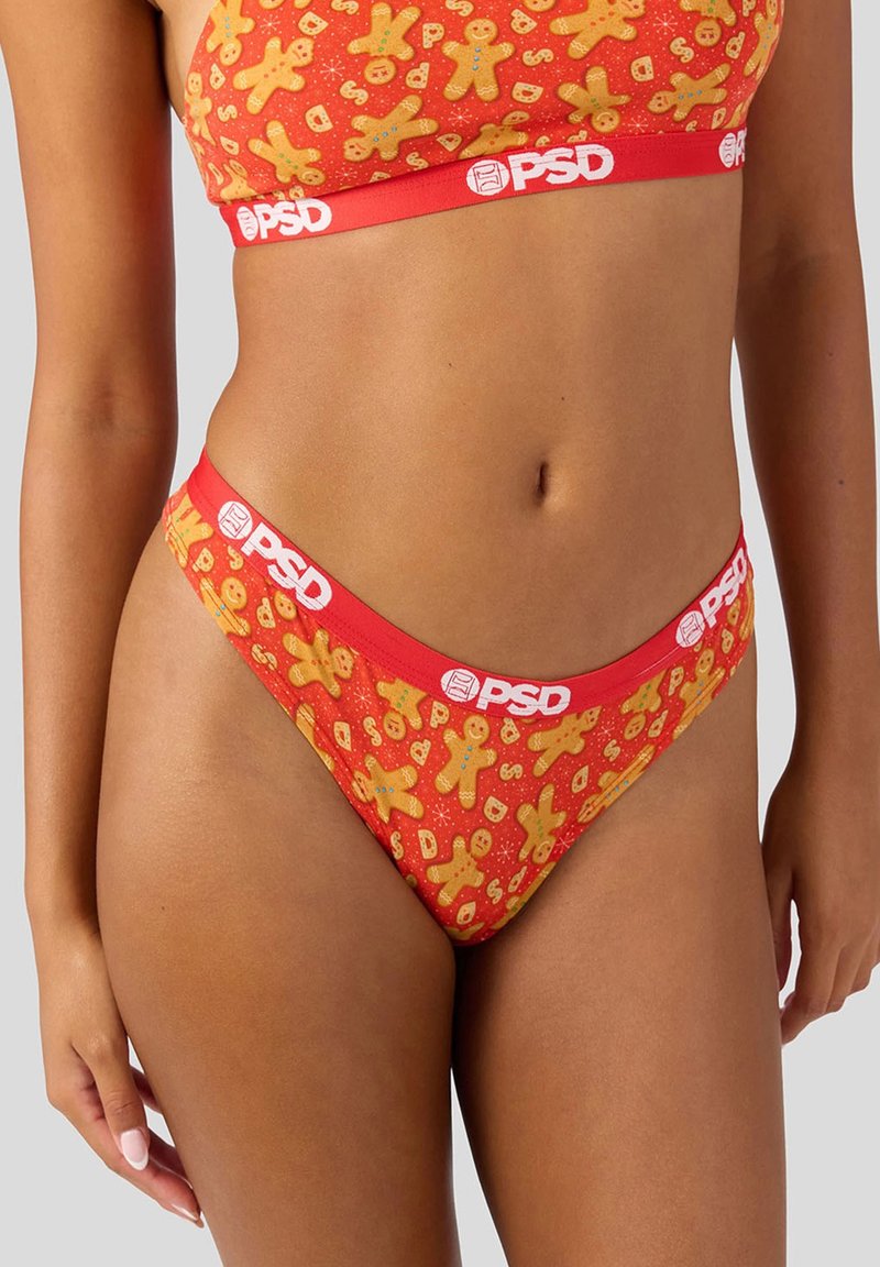 Set di biancheria intima rossa con stampa di pan di zenzero e dettagli arancioni. Il materiale è liscio, con un elastico in vita con logo.