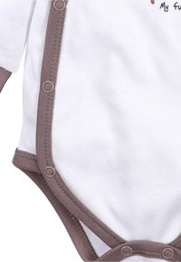 Witte babybodysuit met lange mouwen, voorzien van bruine rand en drukknoopsluitingen aan de zijkant, zachte stof en speelse tekst.