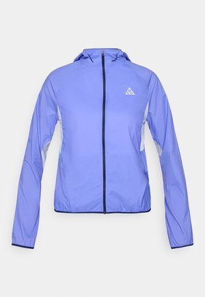 Ελαφρύ μωβ μπουφάν με φερμουάρ και κουκούλα, με γκρι πάνελ διακοσμήσεις και τρίγωνο λογότυπο στο αριστερό στήθος. Ομαλή υφή.