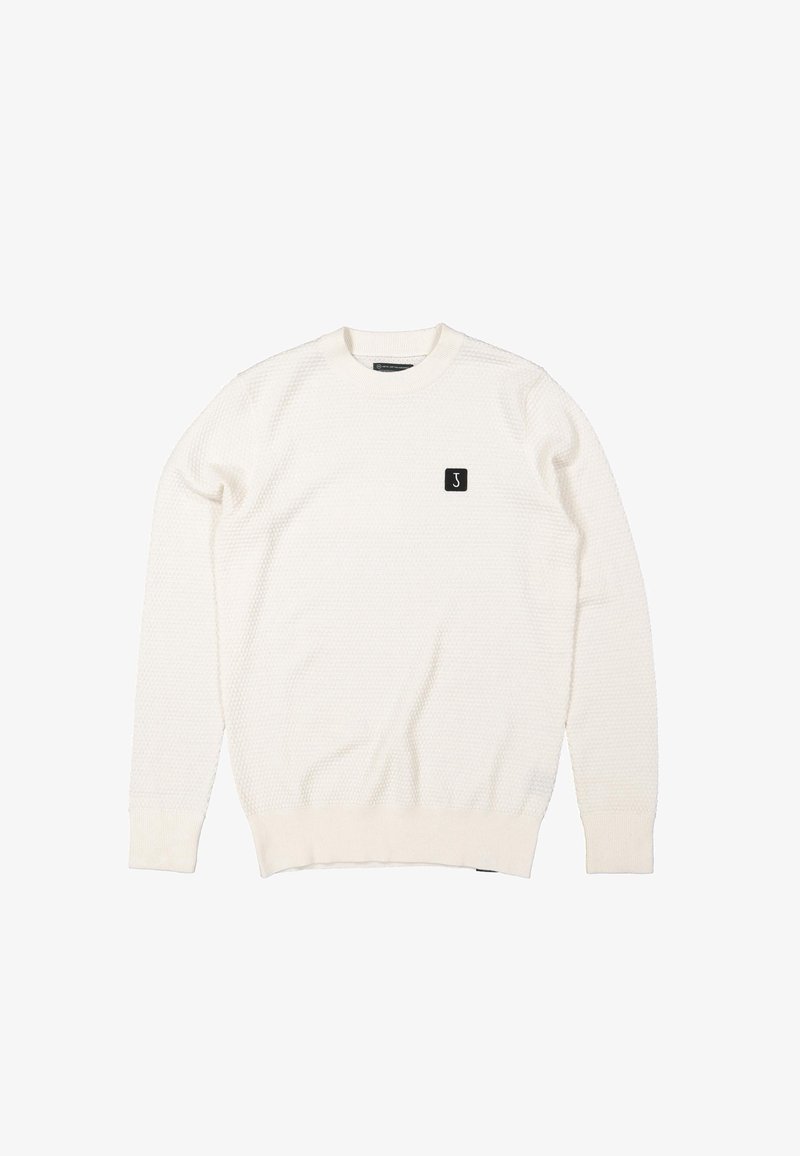 Pull blanc texturé à manches longues et col rond, avec poignets et ourlet côtelés, présentant un petit patch logo rectangulaire noir sur la poitrine gauche.