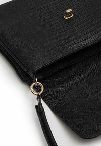 Sort struktureret clutch taske lavet af syntetisk materiale, med en guld hardware trykknaplukning og en dekorativ ring til montering af en rem eller kæde.