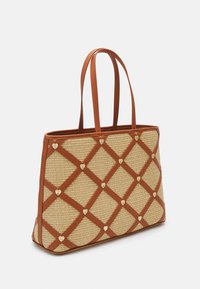 Tanzak geweven draagtas met een gestructureerd ontwerp, benadrukt met bruin lederen handvatten en gouden hartvormige versieringen in een diamanten patroon.