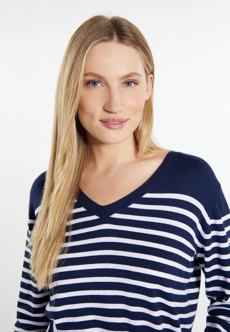 Granatowy sweter w białe paski, dzianinowy, z dekoltem w serek i długimi rękawami, o miękkiej fakturze i luźnym kroju.