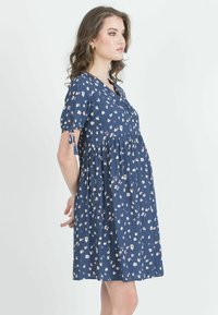 Marineblaues Blumenkleid mit kurzen Ärmeln, V-Ausschnitt und gerafftem Taillenbund. Besteht aus leichtem Stoff und hat ein dezentes cremefarbenes Blumenmuster.