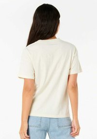 T-shirt en coton crème à manches courtes et coupe droite ; possède un col rond classique et une texture lisse.