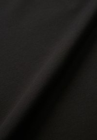 Tessuto di cotone nero che mostra una superficie liscia con una leggera lucentezza, caratterizzato da sottili scanalature e un morbido cadere.