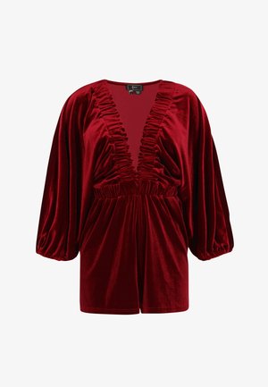 Tuta corta in velluto rosso con scollatura a V profonda, dettagli arricciati con volant, ampie maniche a sbuffo e vita elastica per una vestibilità aderente.