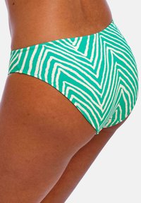 Parte inferior de bikini verde con un patrón en zigzag en blanco. Fabricada con un tejido suave, tiene un corte bajo y una cinturilla elástica.