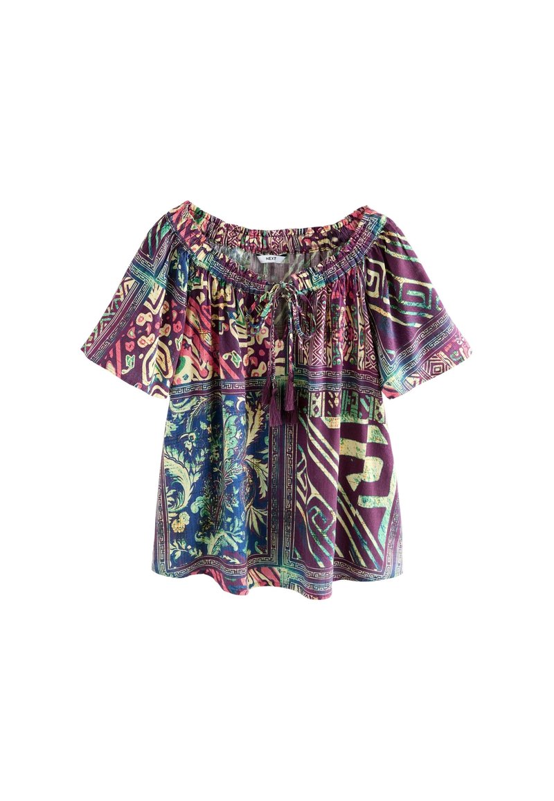 Blouse à manches courtes style bohème avec motifs géométriques et floraux multicolores et col à cordon avec pompons.