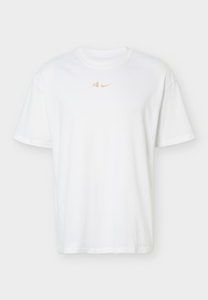 Λευκό T-shirt με κοντό μανίκι και στρογγυλή λαιμόκοψη, με μικρό χρυσό λογότυπο Nike και λογότυπο Kobe Bryant τοποθετημένα στο κέντρο κοντά στη λαιμόκοψη.