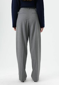 Grey wool trousers with a loose fit, featuring a high waist, front pleats, and two back pockets. Smooth texture and tailored design.