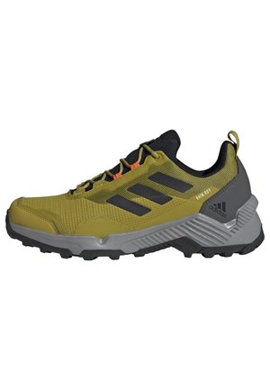 Grøn og grå Adidas trail løbesko med sorte striber, kraftig sål og orange snøredekorationer.