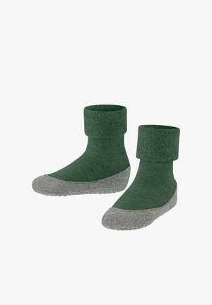 Grüne Baumwollmischsocken mit einem gerippten Bündchen, grauer strukturierter Sohle und Grip-Punkten für mehr Halt. Mittellange Knöchelhöhe mit einer passgenauen Form.