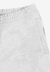 Jasnoszare dresy wykonane z miękkiego, prążkowanego materiału. Posiadają elastyczny pas i boczne kieszenie. Prosty, luźny krój.