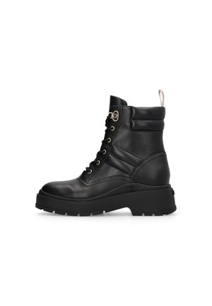 Stivaletto in pelle nera con suola spessa, design con lacci, accessori in metallo dorato e linguetta nella parte posteriore. Presenta un collo imbottito.