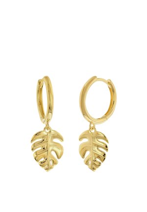 Gold hoop earrings with small hanging charms shaped like detailed tropical monstera leaves.