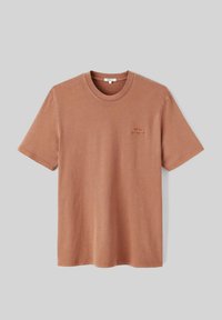 T-shirt à manches courtes de couleur rouille, fabriqué en coton, avec un col rond et un petit design brodé sur la poitrine.