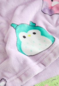 Lila fleecefilt med en söt uggledesign i teal och vitt, med mjuk textur och detaljerade, kontrasterande accenter.