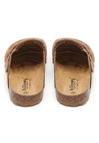 Les sandales en daim marron présentent un design ouvert avec une large zone pour les orteils, une semelle en liège et un logo subtil sur la semelle intérieure. Dessus texturé et intérieur doux.