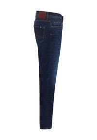 Slim-fit tmavomodré rifľové nohavice s hladkou textúrou, ktoré majú päť vreciek a hnedú koženú nášivku na páse.