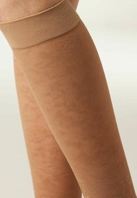Beige mönstrade strumpbyxor med blommigt mönster, som har en mjuk textur och elastiskt midjeband för en bekväm passform.