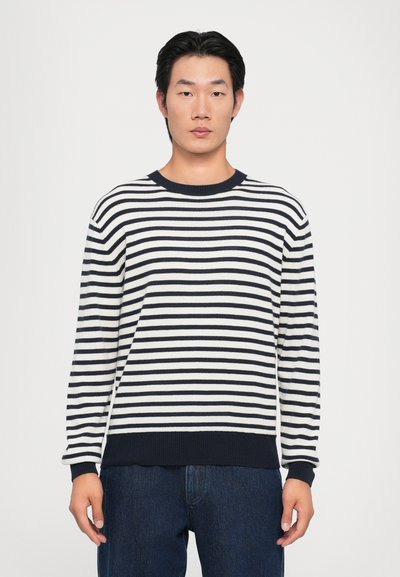 Pull rayé en tissu doux, avec des rayures horizontales bleu marine et blanches, des poignets côtelés et un col rond.